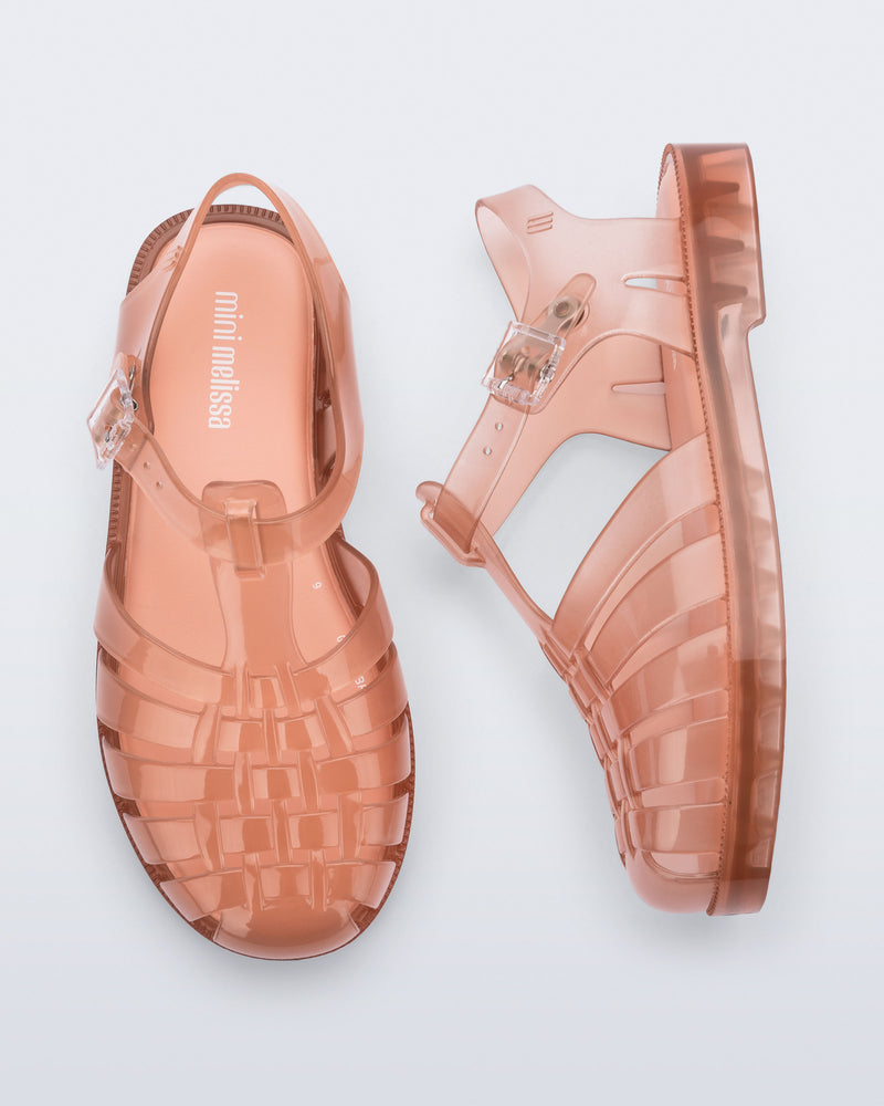 Side and top view of a pair of transparent beige/pink Possession kids sandals