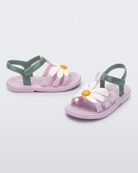 Side and angled view of a pair of pink Hip Bloom baby sandals with white flower and green ankle strap