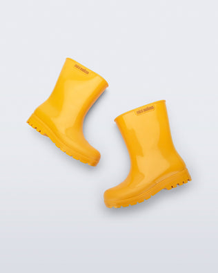 Side view of a pair of orange Welly kids rainboots