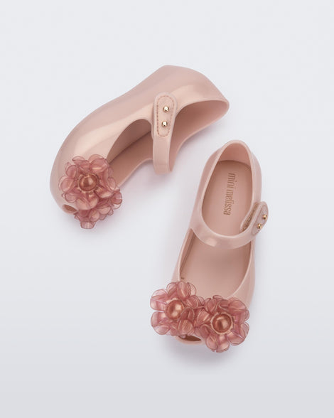 Side and top view of a pair of pearly pink Ultragirl Sprngtime baby flats with two clear pink flowers and peep toe.