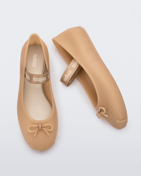 Top and side view of a pair of Melissa Sophie ballet flats in beige with M-logo strap and bow applique