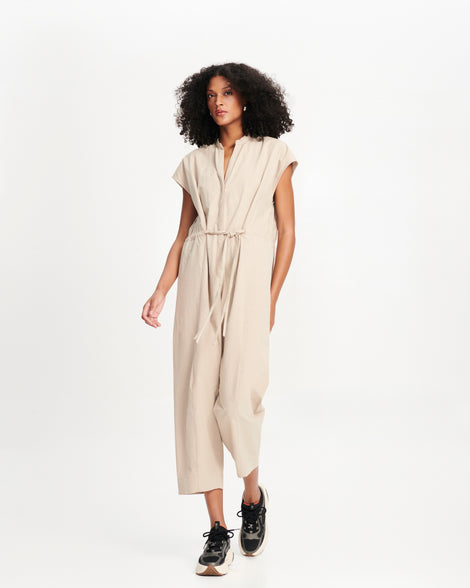 Model in a beige outfit wearing a pair of black X Loop sneakers with beige soles
