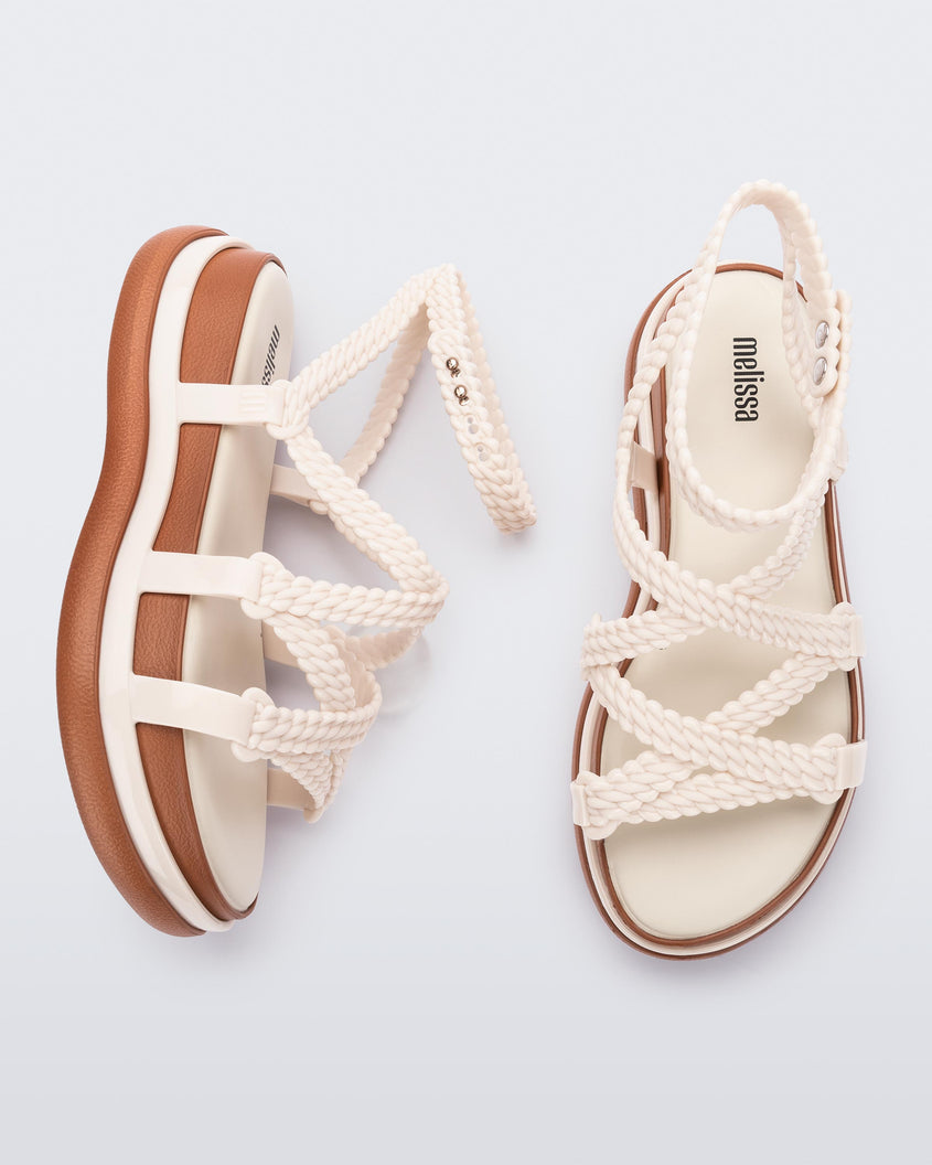 A top and side view of a pair of beige Melissa Buzios platform sandals with multiple textured straps that mimic sisal braids across the front of the shoe as well as an ankle strap
