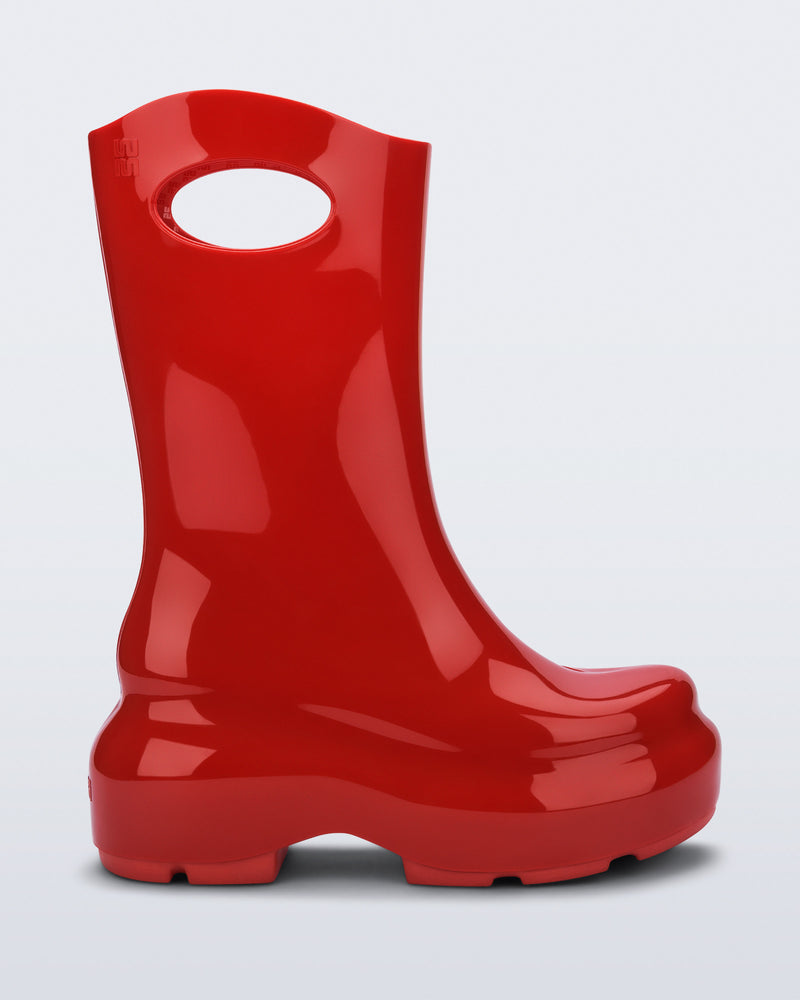 Side view of a red Ultra platform rain Boot with circle cutout on top