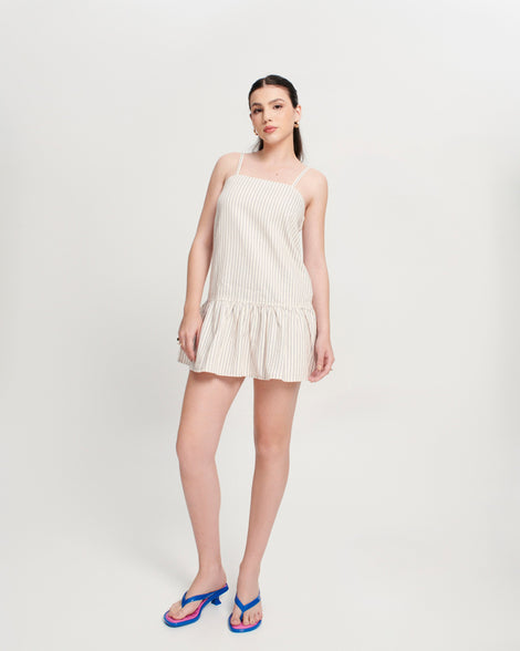 Model in a beige dress wearing a pair of blue Flip Flop Kitten Heels with pink insole