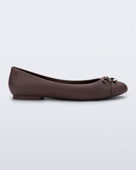 Side view of a brown Melissa flat with bow detail with gold accents on the bow