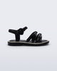 Side view of a black Aurora baby sandal with beige trim