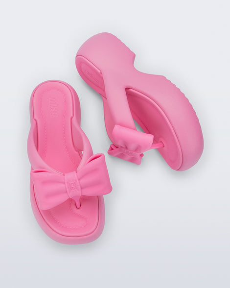 Side and top view of a pair of pink Free Fuzzy Platform flip flops