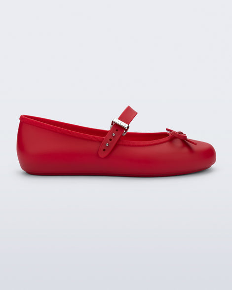 Side view of a red Soft Ballerina Delicate Bow flat with top strap and bow