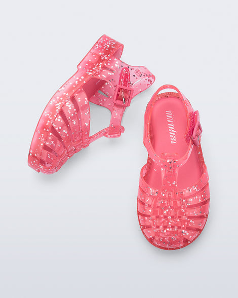 Top and side view of a pair of pink Possession Elements baby sandal with glitter hearts