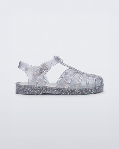 Side view of a glitter/clear/silver Possession kids fisherman sandal