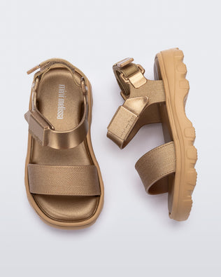 Top and side view of a pair of gold baby Kick Off Sandals