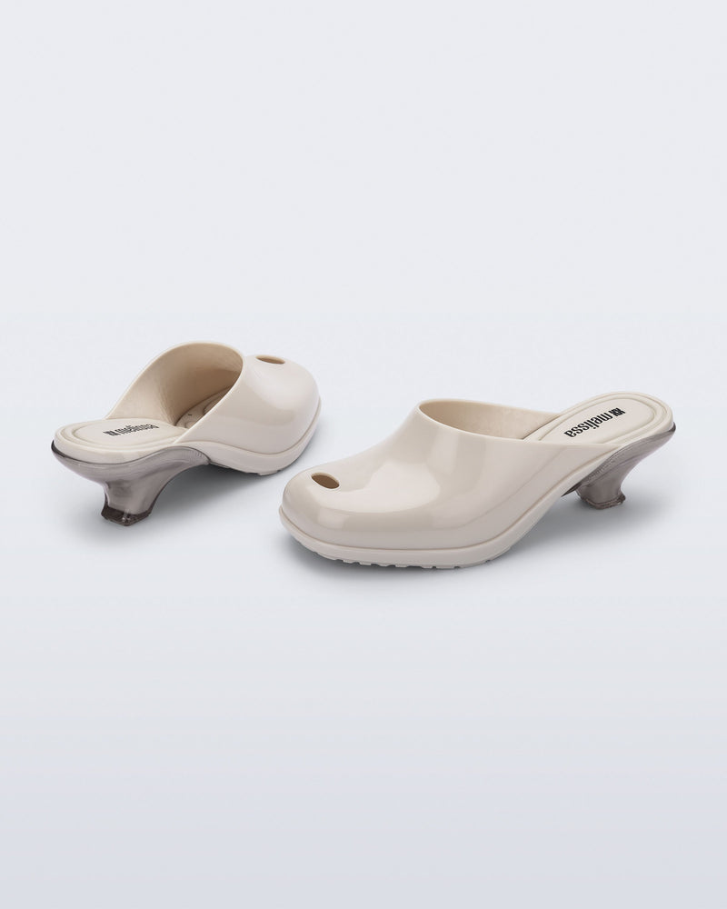 Back and angled view of a pair of light beige Gaia kitten heels with peep toe
