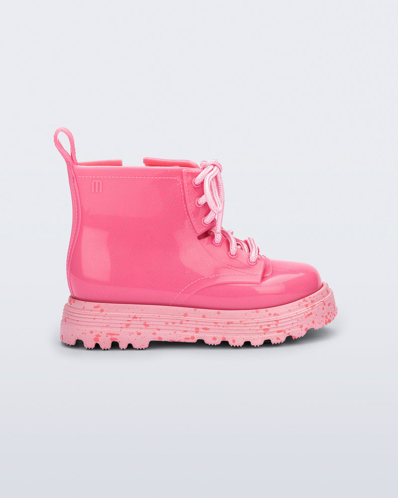 Side view of a pink Coturno baby boot with pink laces.