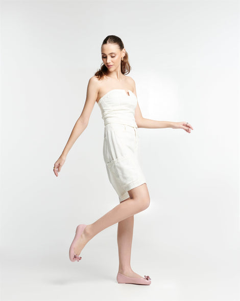Model in a white dress wearing a pair of pink Sweet Love Glam ballerina flats with pink chrome bow