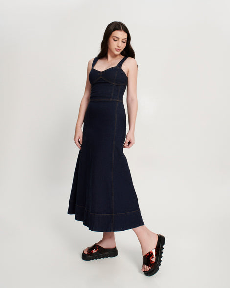 Model in a black dress wearing a pair of black/tortoise Cozy Cross platform sandals with crisscross top straps