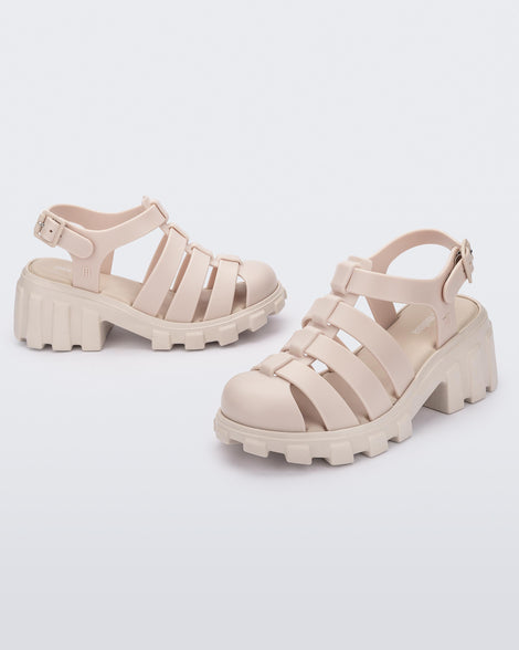 Side and angled view of a pair of beige Megan kids heel sandals.