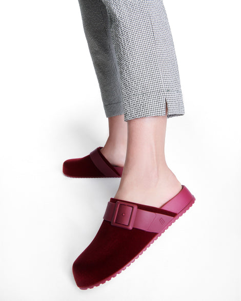 Model's legs wearing a pair of red Cozy Clog Velvet slides