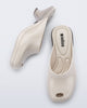Top and side view of a pair of light beige Gaia kitten heels with peep toe