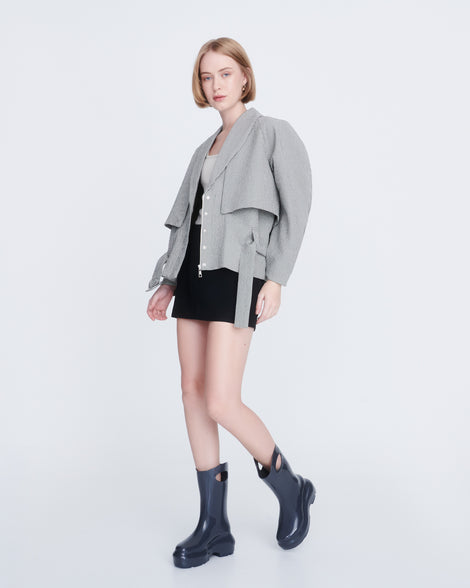 Model in a black dress and grey coat wearing a pair of grey Ultra platform rain Boot with circle cutout on top