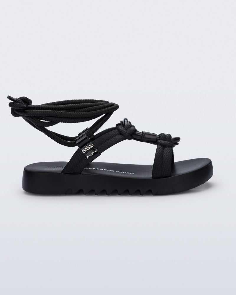 Side view of a black Kirk + Alexandre Pavao sandal with ankle strap