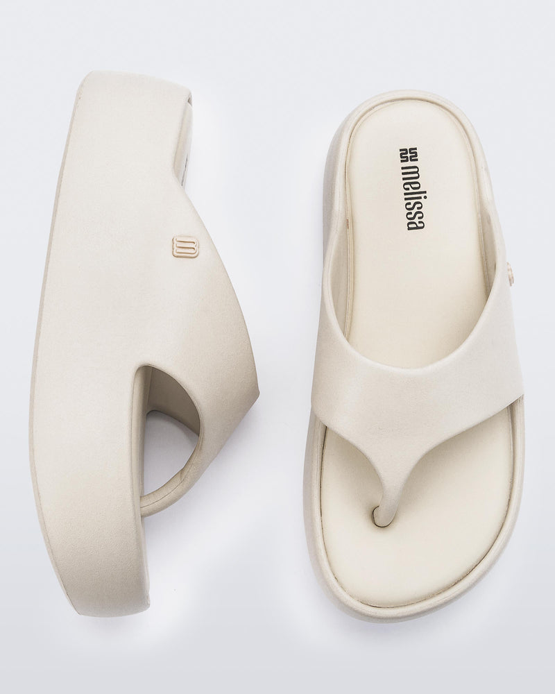 Side and angled view of a pair of beige Free Platform Thong sandal