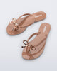 Top view of a pair of brown Harmonic Iris flip flops with rose gold bow