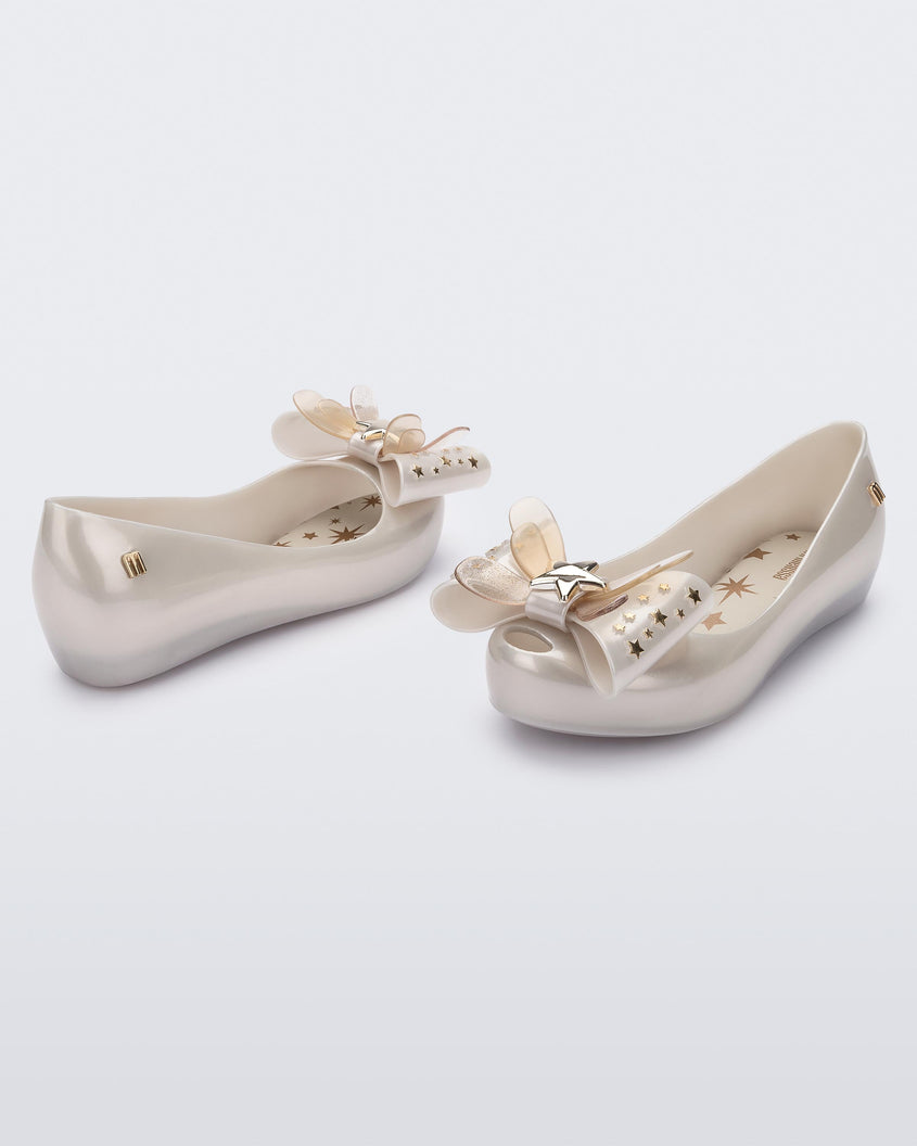 Angled view of a pair of Mini Melissa Ultragirl peeptoe ballet flats in white with star printed butterfly bow applique. 