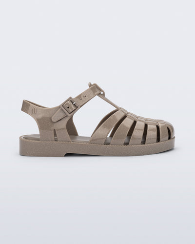 Side view of a glitter beige kids Possession fisherman style sandal.