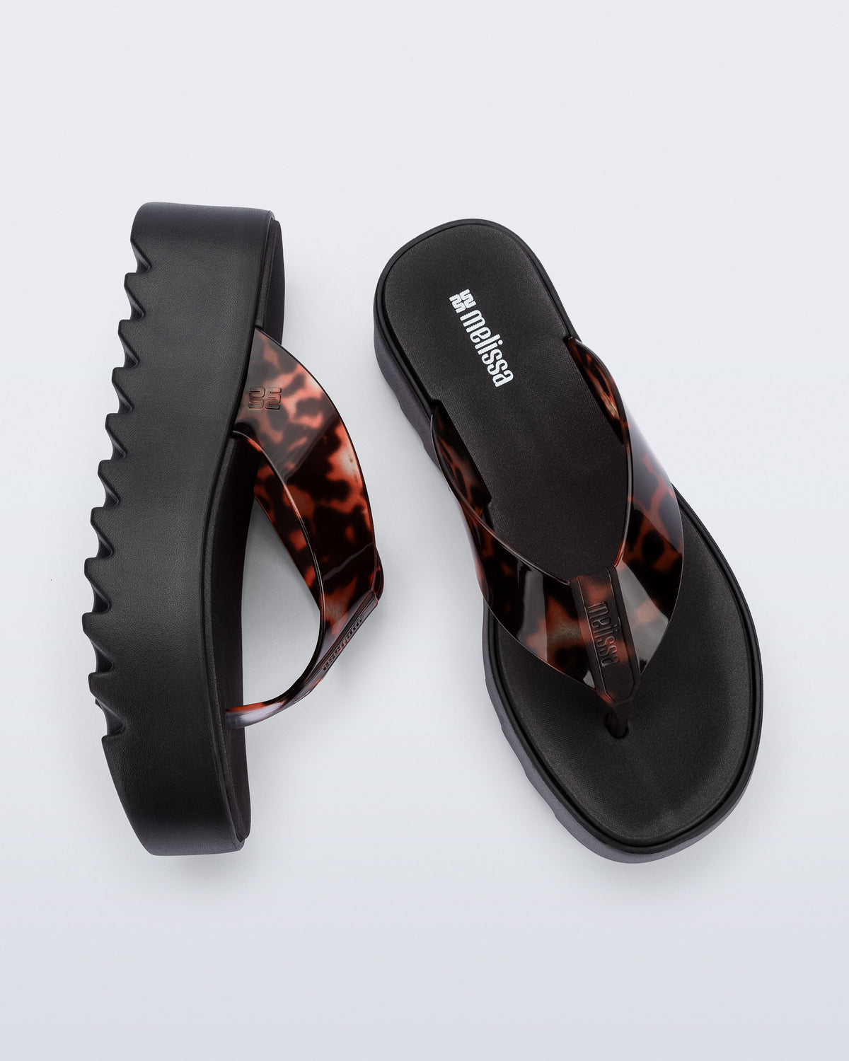 Angled and top view of a pair of black Thong Platform flip flops with tortoise colored strap