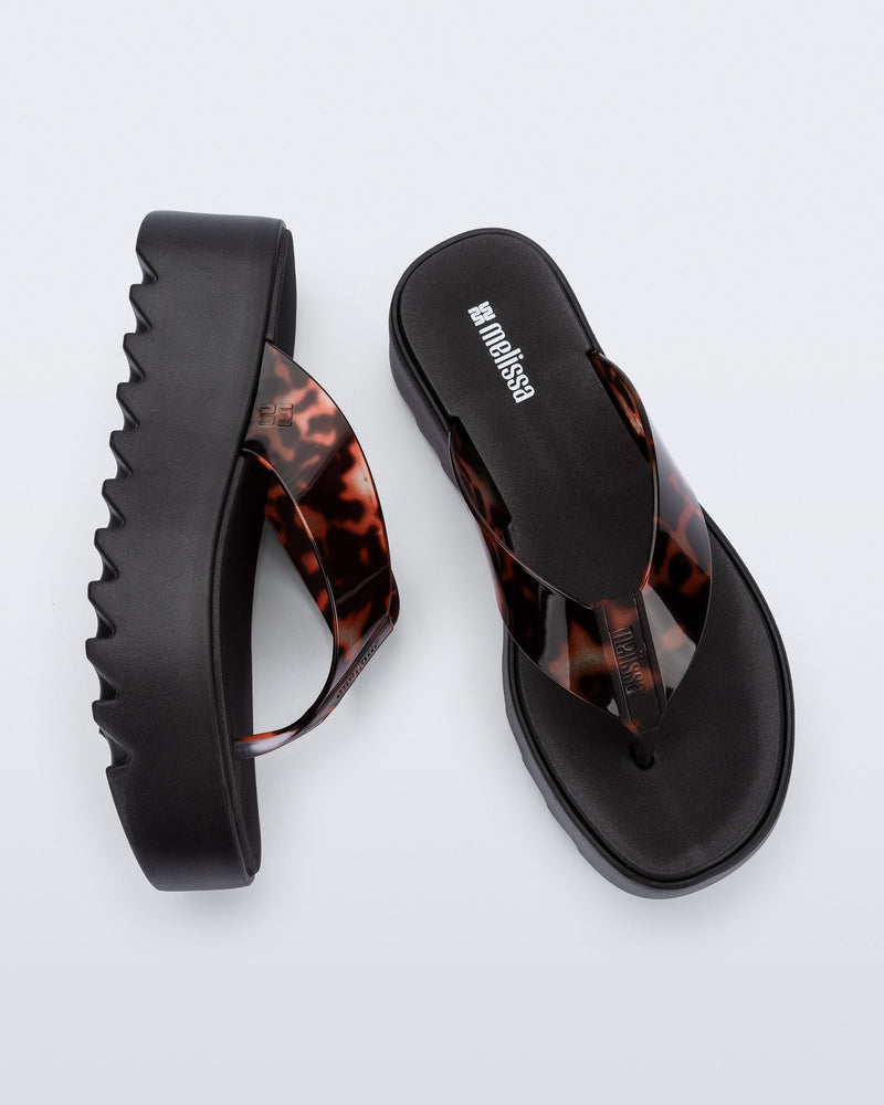 Angled and top view of a pair of black Thong Platform flip flops with tortoise colored strap