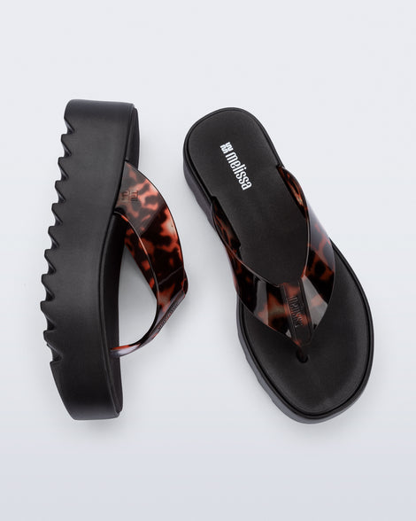 Angled and top view of a pair of black Thong Platform flip flops with tortoise colored strap