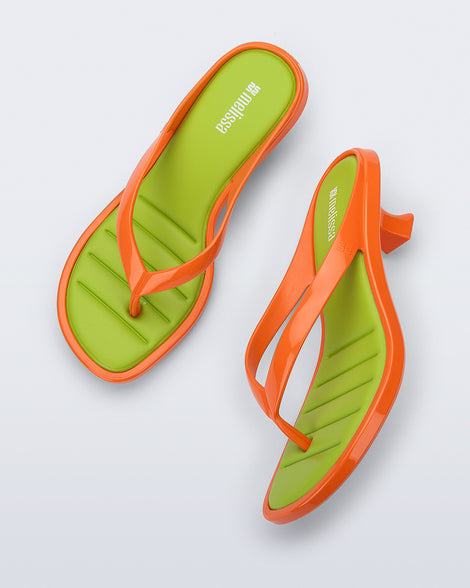 Top and side view of a pair of orange Flip Flop Kitten Heels with green insole