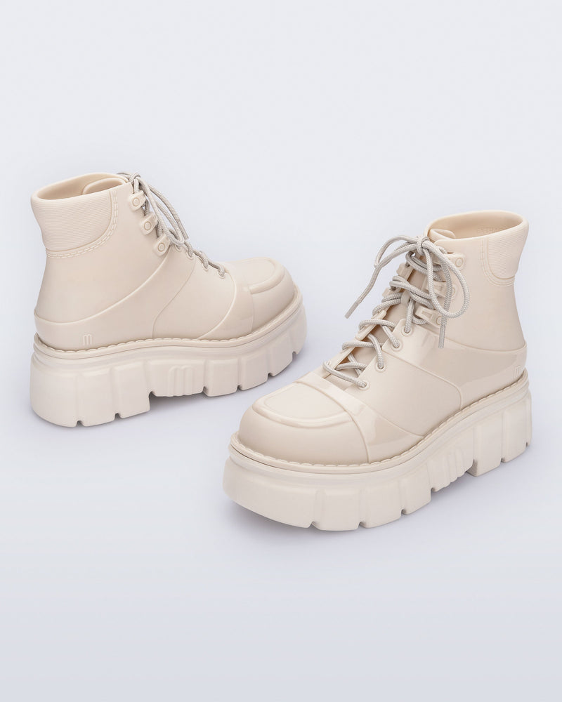 Back and side angled view of a pair of beige Rebel Boots with laces