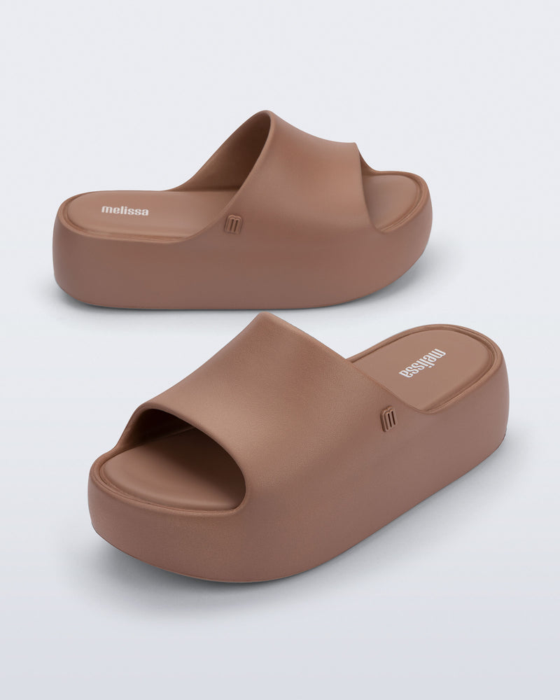 Side and angled view of a pair of brown Free Platform Slide sandals