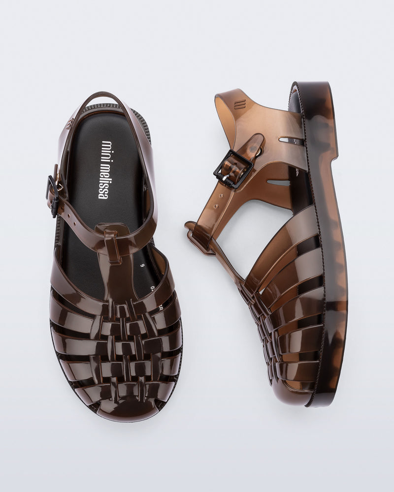 Side and top view of a pair of transparent brown Possession kids sandals