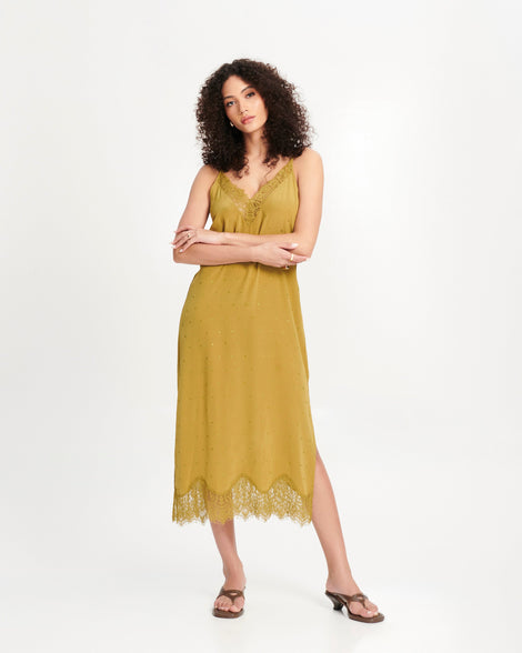 Model in mustard dress wearing a pair of brown Layla kitten heel flip flops