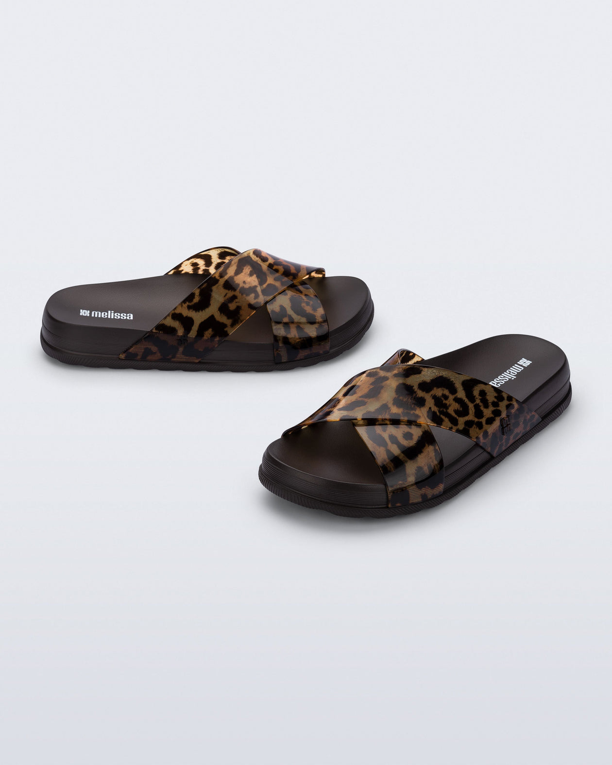 Side and angled view of a pair of dark brown/tortoise Cozy Cross sandals with crisscross top straps
