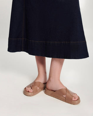 Model's legs in a pair of brown Cozy Cross sandals with crisscross top straps