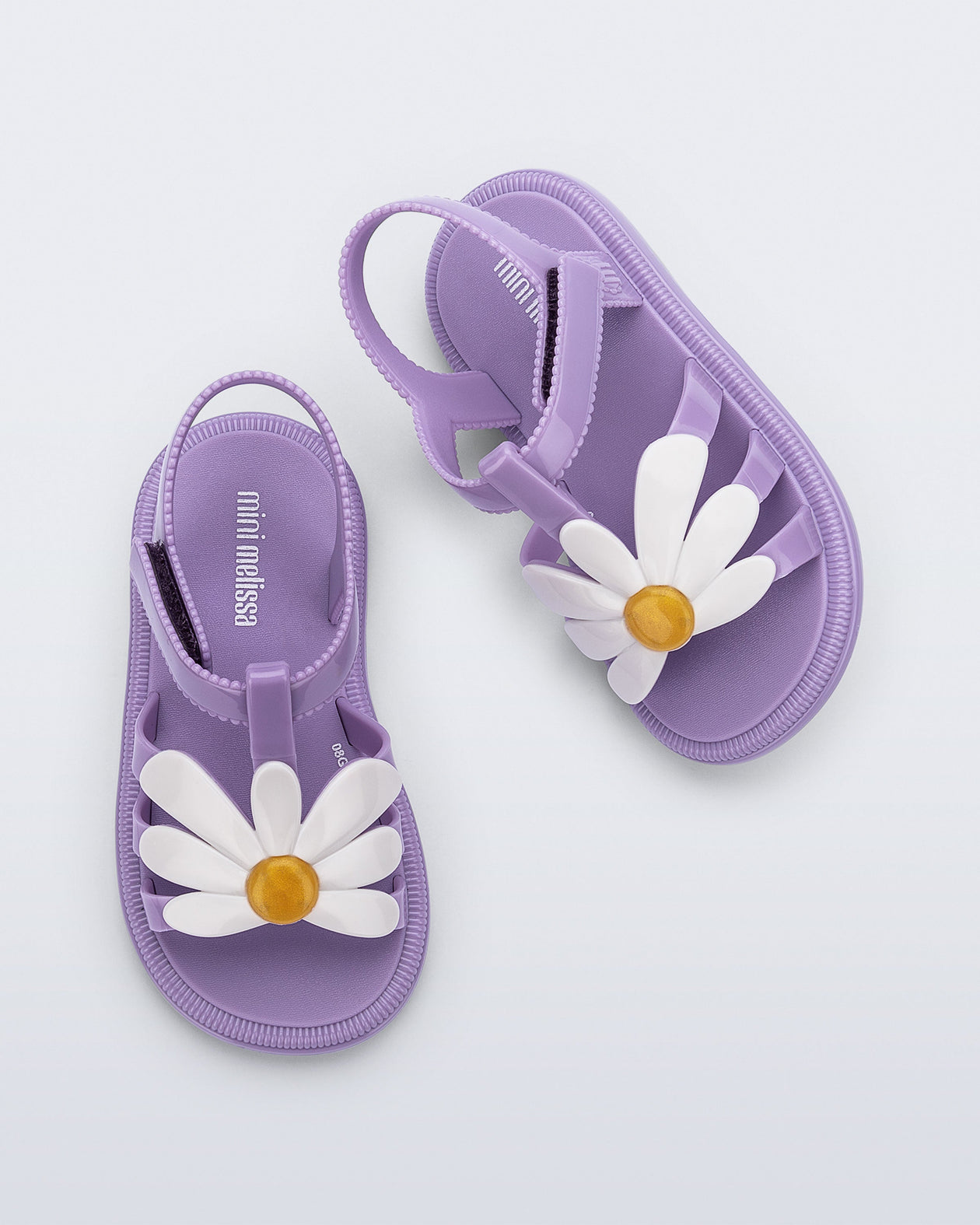 Top view of a pair of purple Hip Bloom sandals with a white flower on top