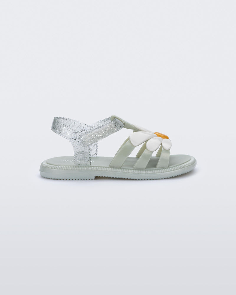 Side view of a metallic green Hip Bloomy baby sandal with white daisy on top