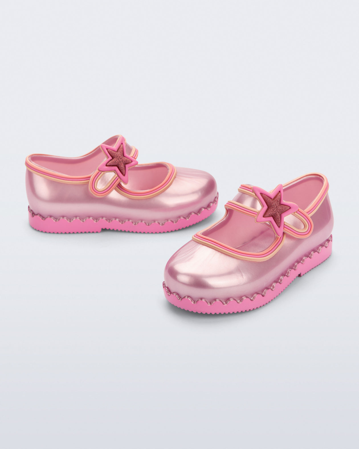 Side and angled view of a pair of pearly pink Hip Ballerina Star baby flats with star on upper strap