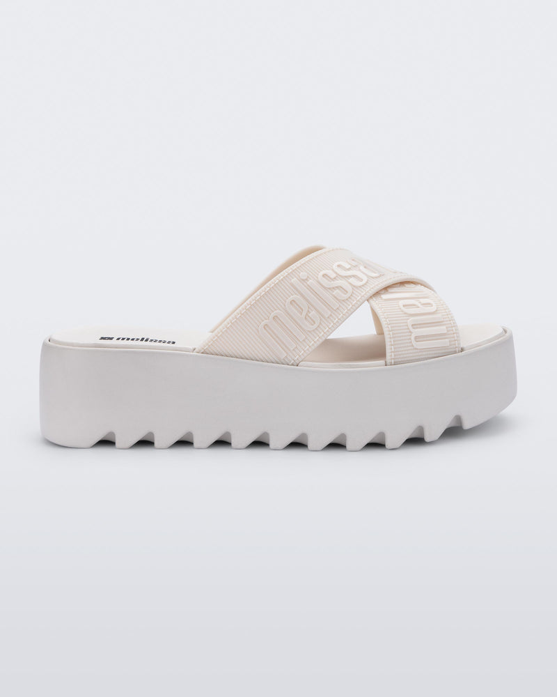 Side view of a beige M Lover Cross Strap platform slide