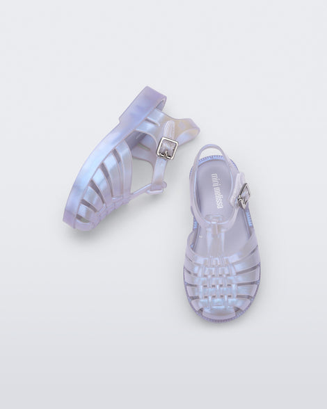 An top and side view of a pair of pearly blue Mini Melissa Possession sandals with a fisherman sandal design