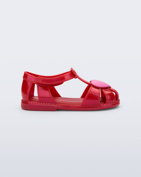 Side view of a red Hip Heart Ballerina baby sandal with  pink heart on front