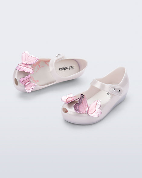 Top and angled view of a pair of pearly white Ultragirl Butterfly baby flats with pink butterflies on top