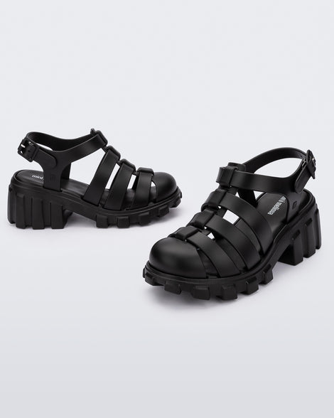 Side and angled view of a pair of black Megan kids heel sandals.
