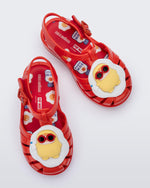 Top view of a pair of red Possession + Pop Mart Pucky fisherman baby sandals