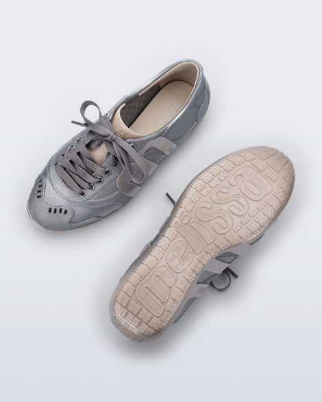 Top and bottom view of a pair of silver Motion sneakers with grey laces