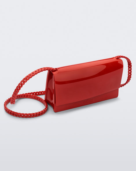 Angled view of the Melissa party handbag in red with braided strap.